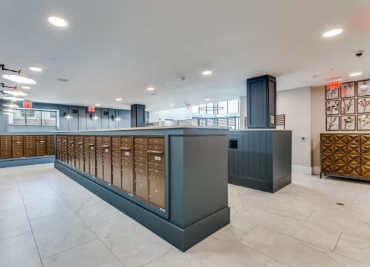 a large lobby with a counter with mailboxes and a staircase
