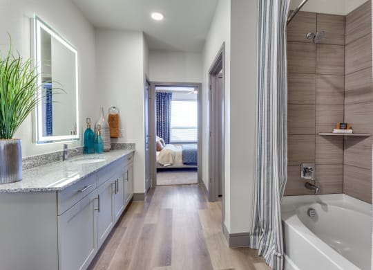 a bathroom with a tub and a shower and a sink