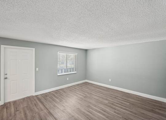 A room with a white door and a window with blinds.