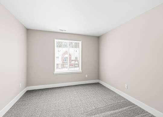 an empty room with white walls and a window