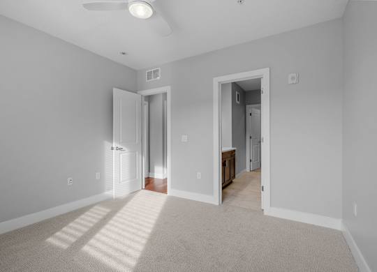 a spacious living room with gray walls and a carpeted floor