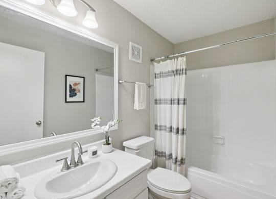 A bathroom with a white sink, toilet, and bathtub.