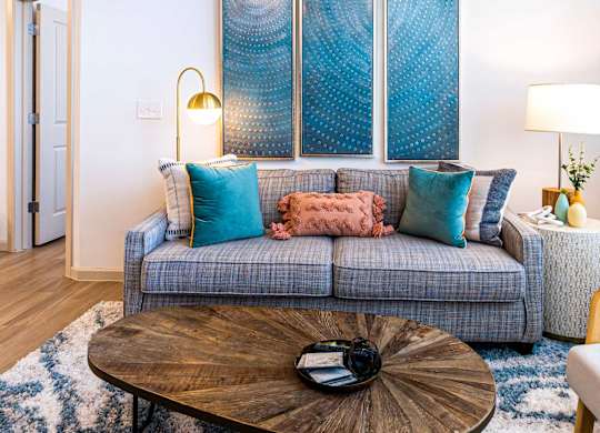 A living room with a grey couch and a wooden coffee table.