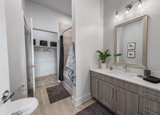 A bathroom with a toilet, sink, and mirror.