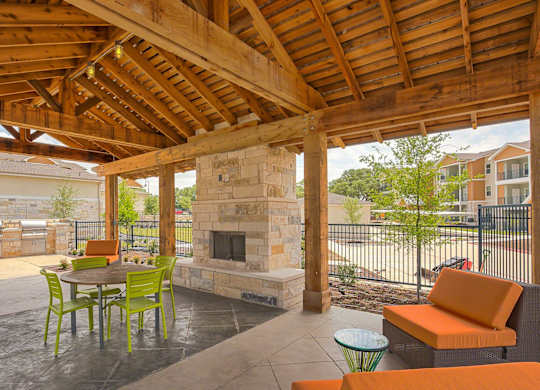 A patio with a fireplace and chairs.