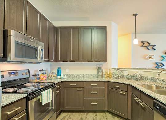A kitchen with brown cabinets and a stainless steel refrigerator.