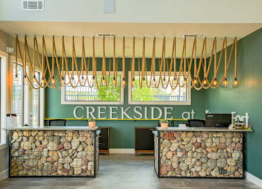 A reception area with a green wall and a sign that says CREEKSIDE at the top.