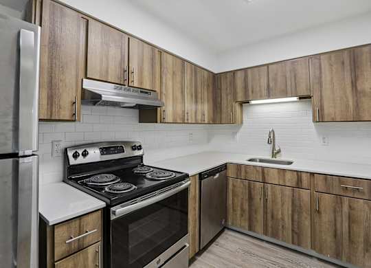 A kitchen with wooden cabinets and a stove top oven.