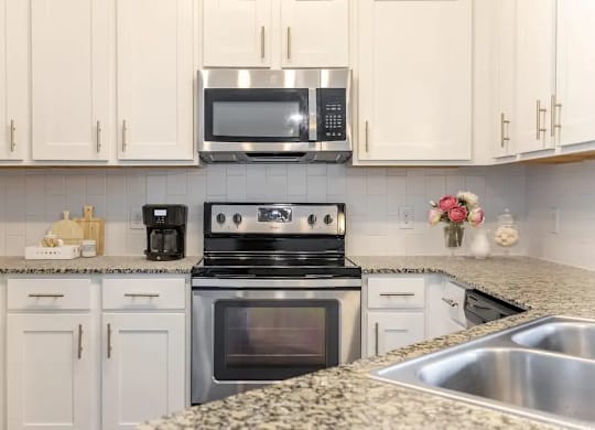 A kitchen with a stove, oven, microwave, and refrigerator.