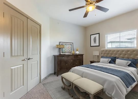 A bedroom with a bed, dresser, and a ceiling fan.