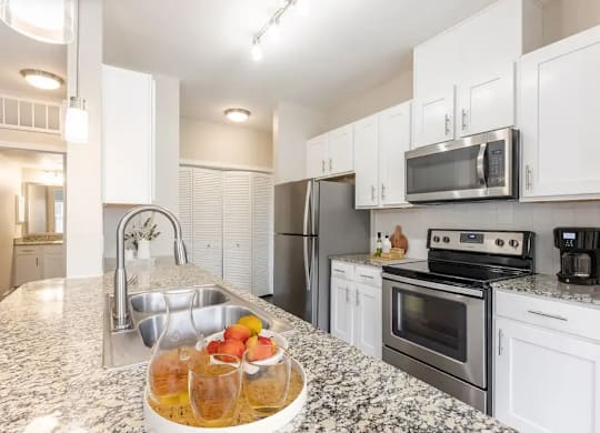 A kitchen with a granite countertop and stainless steel appliances.