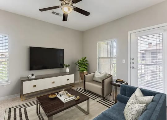 A living room with a television, a sofa, a coffee table, and a potted plant.
