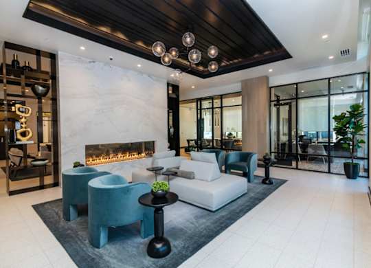 A modern living room with a fireplace and a variety of seating options.