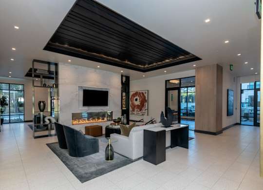 A modern living room with a fireplace and a black ceiling.