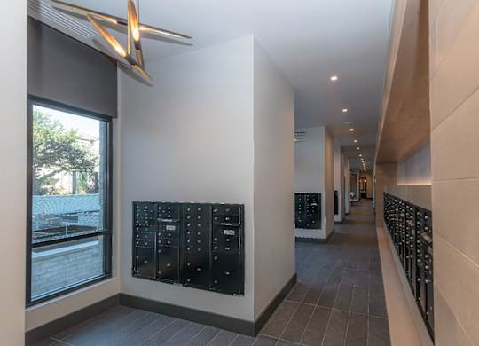 A long hallway with a black mailbox on the wall.