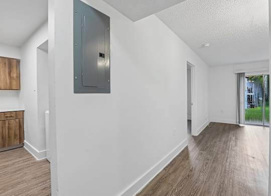 A room with a white wall and a wooden floor.