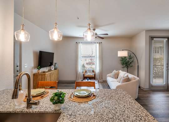 A kitchen with granite countertops and a ceiling fan.