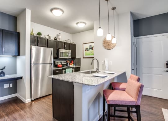 a kitchen with a island and a stainless steel refrigerator