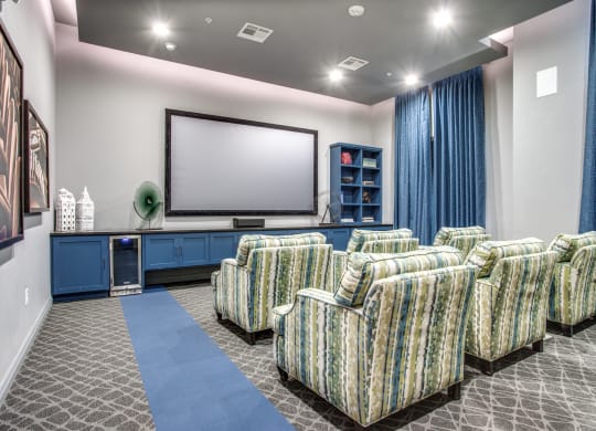 a theater room with chairs and a television on the wall
