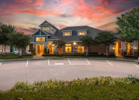 A large house with a parking lot in front of it.