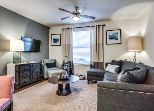 a living room with a couch and chair and a ceiling fan