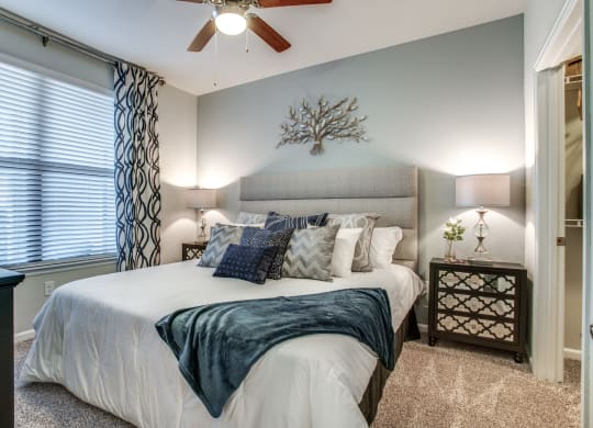 a bedroom with a large bed and a ceiling fan