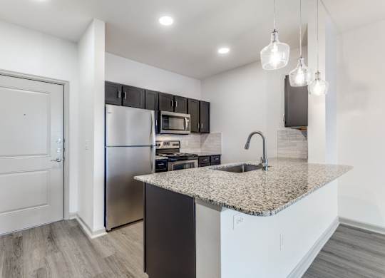 A kitchen with a granite countertop and stainless steel appliances.