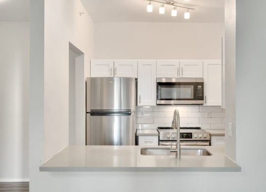 a kitchen with stainless steel appliances and white cabinets