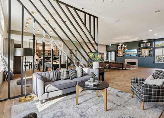 A living room with a grey sofa, a black and white checkered armchair, and a wooden coffee table.