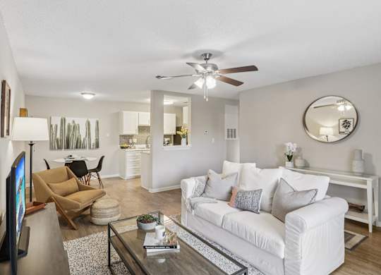 A living room with a white couch and a flat screen TV.