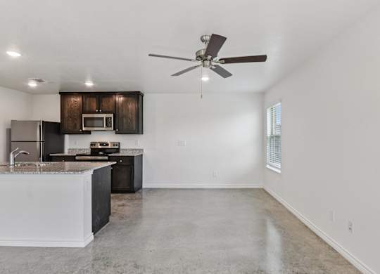 A kitchen with a white countertop and a ceiling fan.