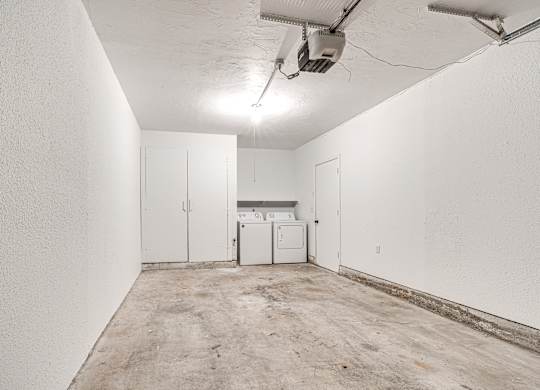 A white wall with a washing machine in the middle.