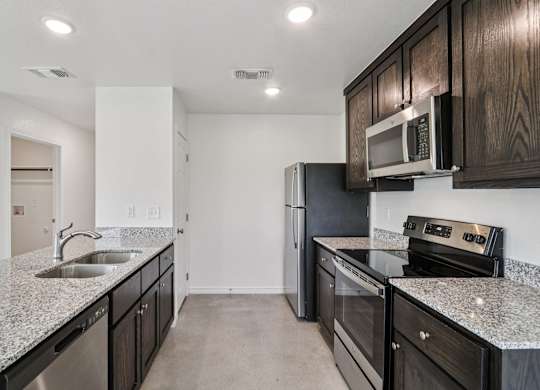 A kitchen with black cabinets and stainless steel appliances.