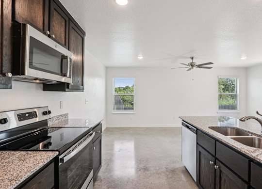A kitchen with black cabinets and granite countertops.