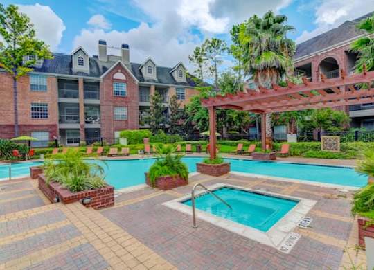 A large building with a pool in front of it.
