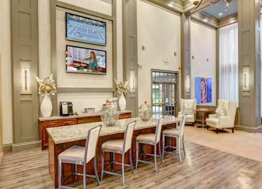 A dining room with a table set for four and a television mounted on the wall.