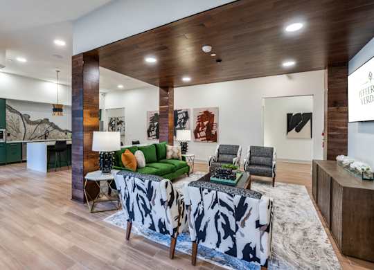 A living room with a green couch and a cowhide rug.