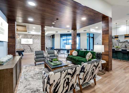 A living room with a green couch and a zebra print chair.