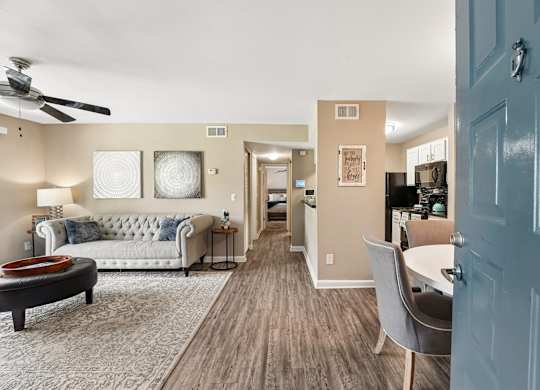 A living room with a couch, a coffee table, and a ceiling fan.