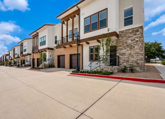 A row of modern houses with a red line in the middle of the street.