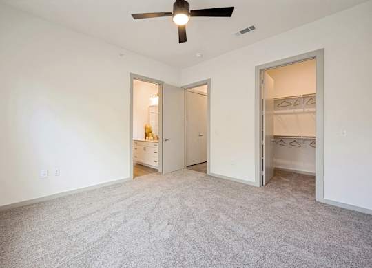 A room with a ceiling fan and carpeted floor.