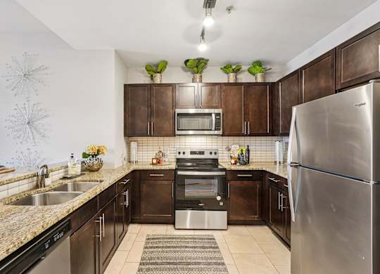 A modern kitchen with dark brown cabinets and stainless steel appliances.