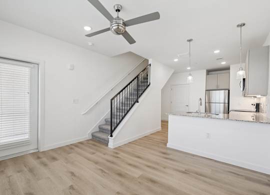 A spacious room with a staircase leading to the upper floor.