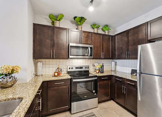 A kitchen with brown cabinets and a stainless steel refrigerator.