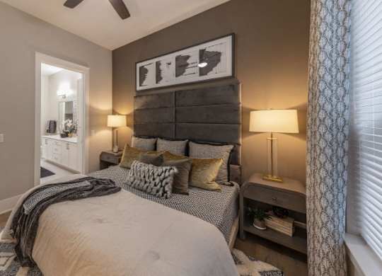 A bedroom with a large bed and a ceiling fan.