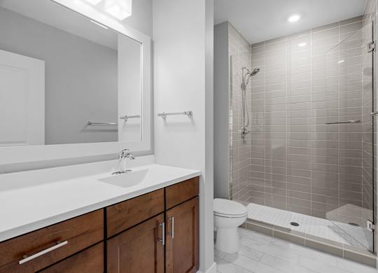a bathroom with a shower sink and toilet and a mirror