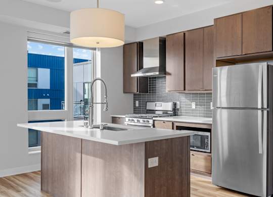 A modern kitchen with a large island and stainless steel appliances.