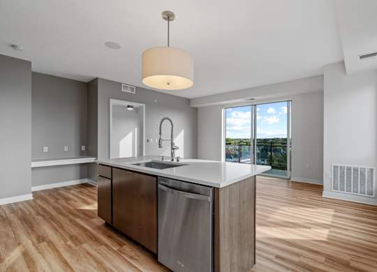 A modern kitchen with a large island and stainless steel appliances.