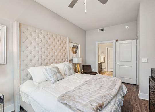 A bedroom with a large bed and a ceiling fan.