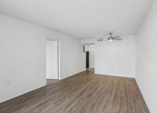 A room with wooden flooring and a ceiling fan.